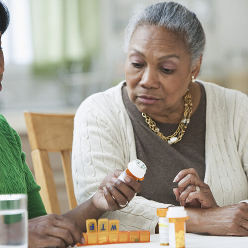 daughter assisting and explaining medicines to mother