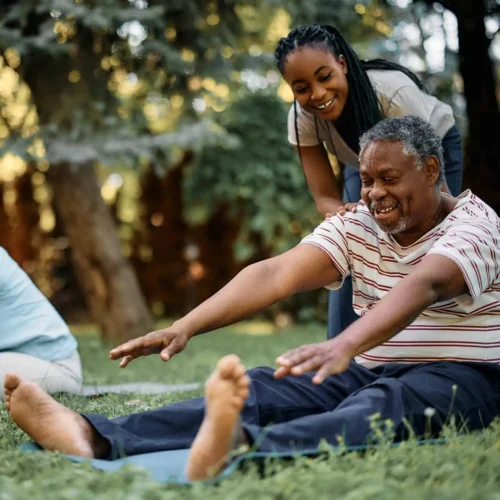 Happy-black-physical-therapist-assists-seniors-during-exercise-class-in-park-1374x1190-1