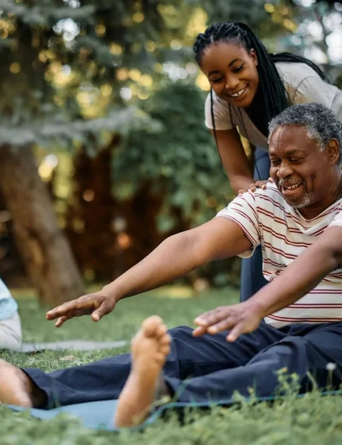 Happy-black-physical-therapist-assists-seniors-during-exercise-class-in-park-1374x1190-1