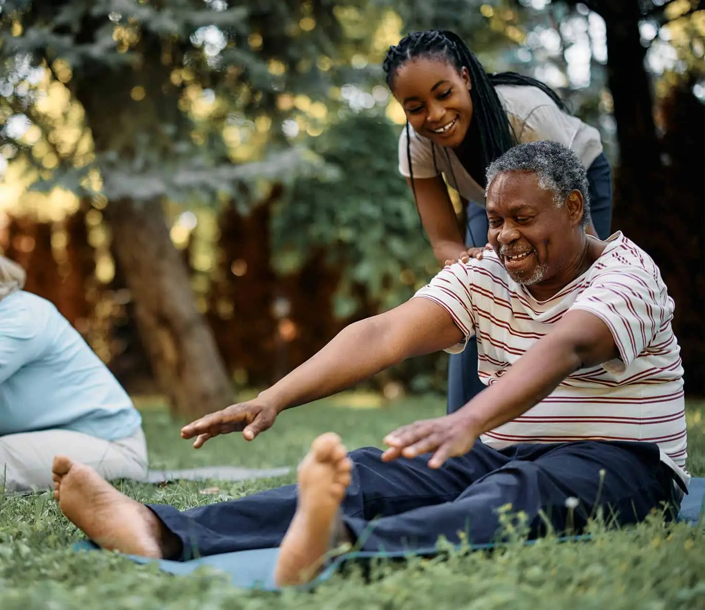 Happy-black-physical-therapist-assists-seniors-during-exercise-class-in-park-1374x1190-1