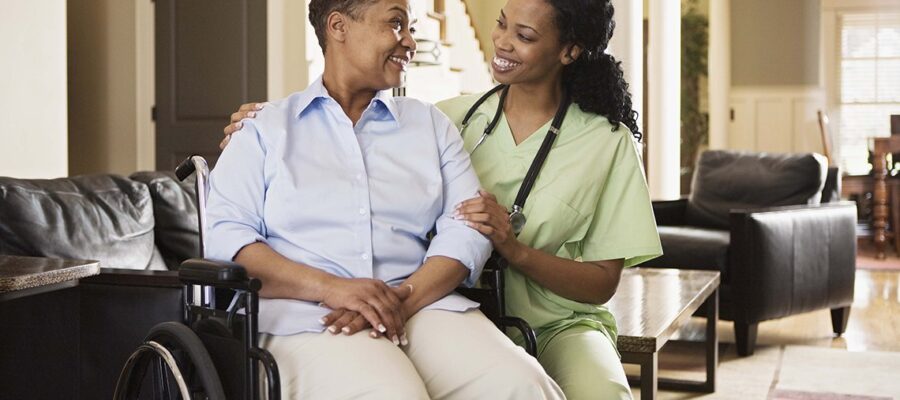 Nurse with woman in wheelchair at home